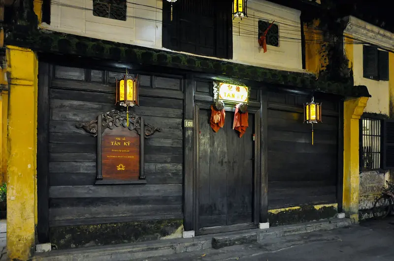Dark timber façade of the Tấn Ký old house in Hội An, hung with lanterns